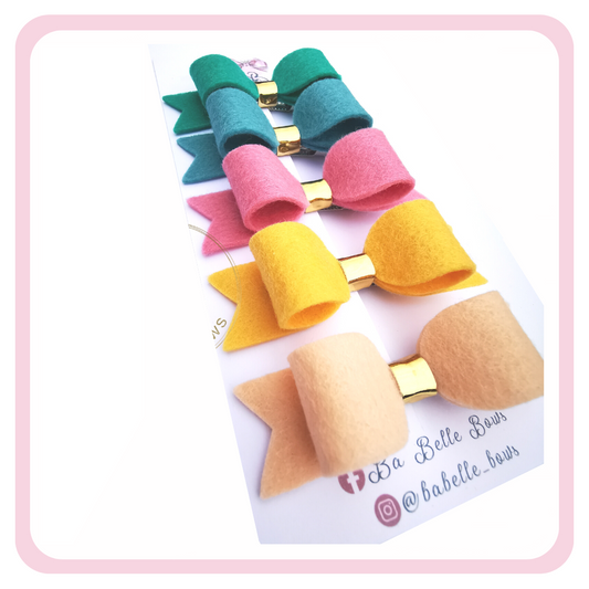 Brighten up your beautiful girl's hair with our 100% wool felt pigtail hair bow clips. Each bow measures 3.25 inches/8cm. This pack comes with 6 different coloured bows:  Almond Cream, Bubblegum Pink, Jade, Pacific, and Dolly.